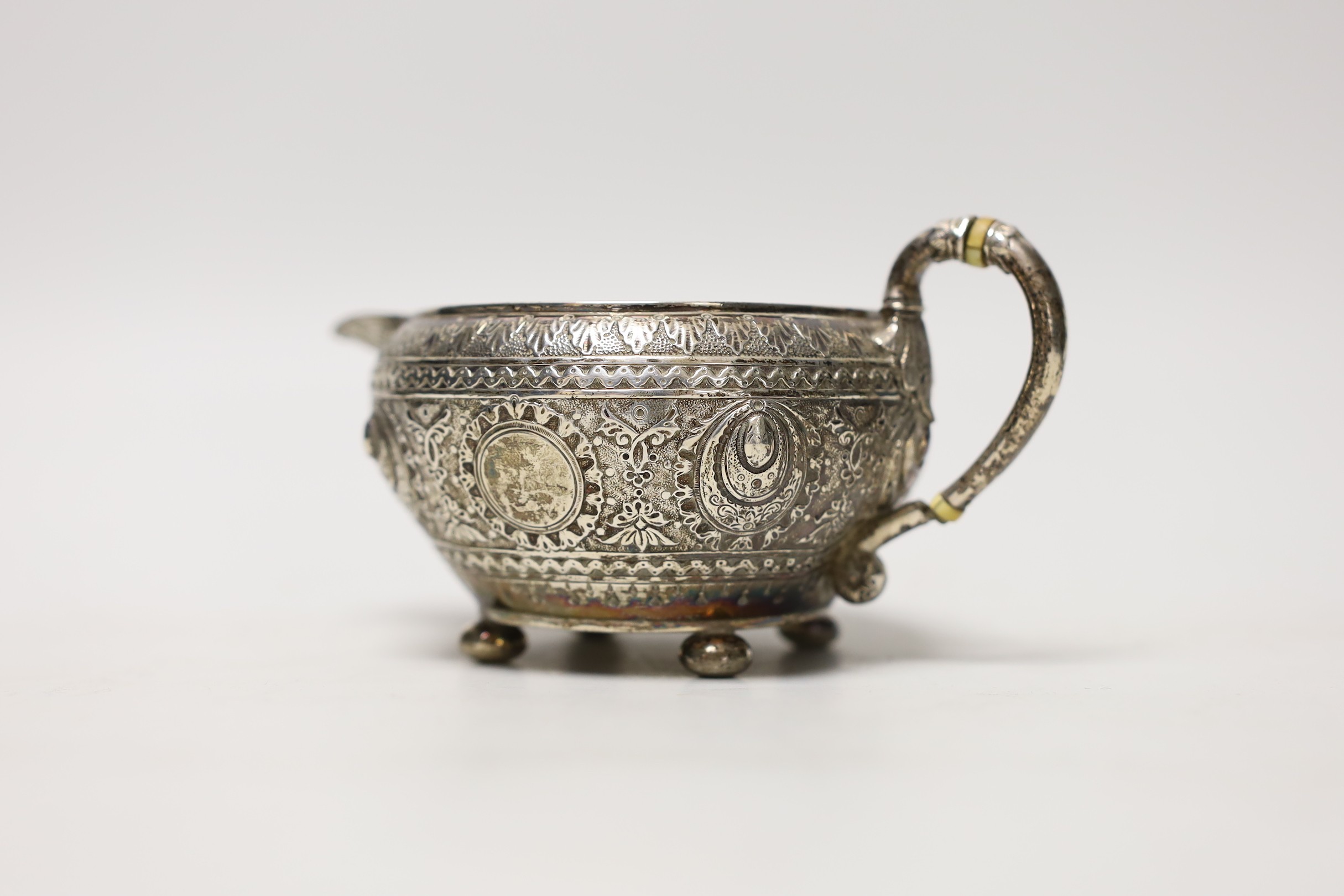A late Victorian embossed silver cream jug, by Walter & John Barnard, London, 1893, height 74mm, gross weight 5oz.
